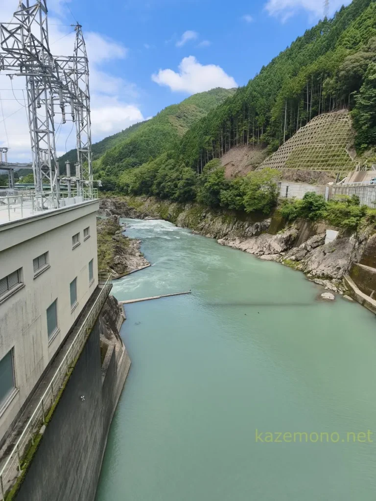 川口ダムの堤体上から見下ろした下流側の那賀川と発電所設備