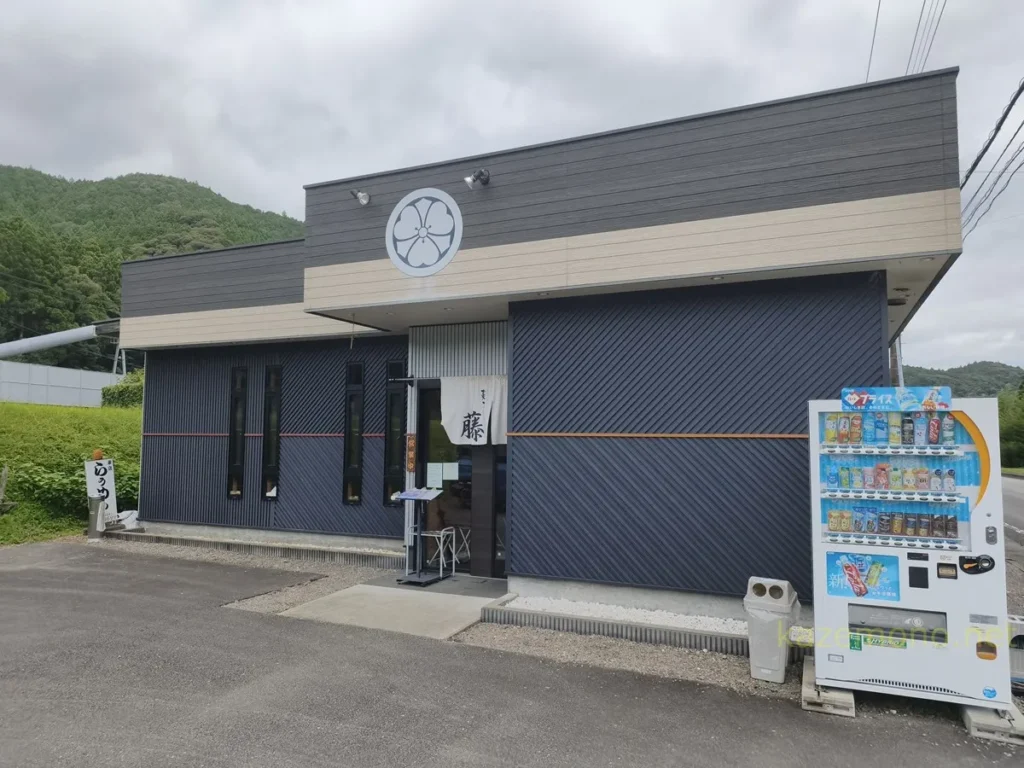 丸い紋のようなマークと暖簾がある麺屋藤の店舗外観