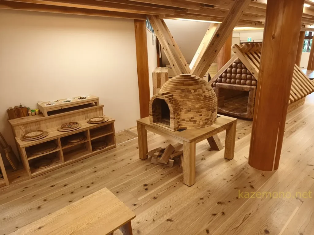 木製のピザ窯と奥にある炭焼き小屋