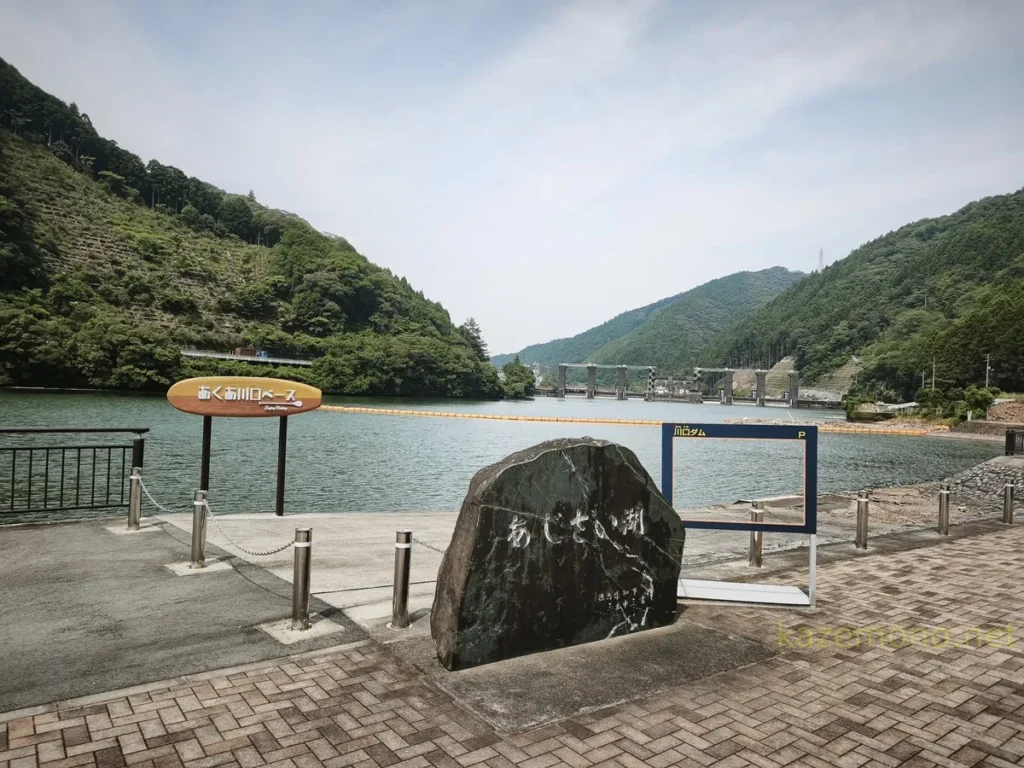 あくあ川口ベースの看板とあじさい湖の石碑、川口ダムを望むダムカード型フォトスポット