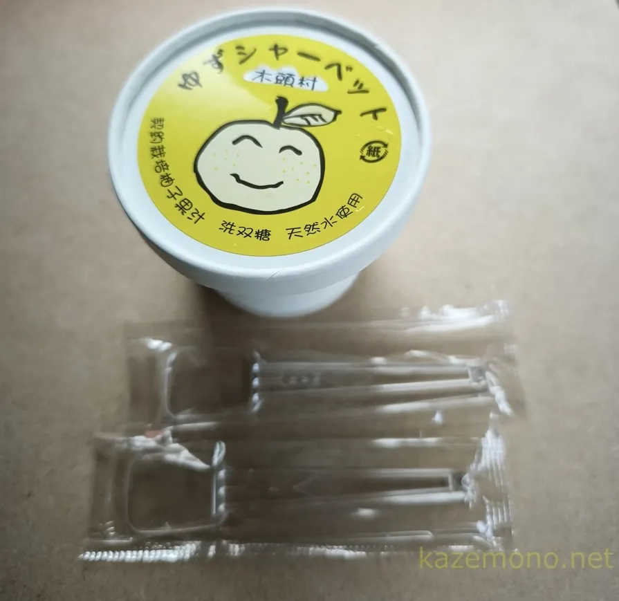 木頭ゆずシャーベットと袋に入ったプラスチックスプーン2本