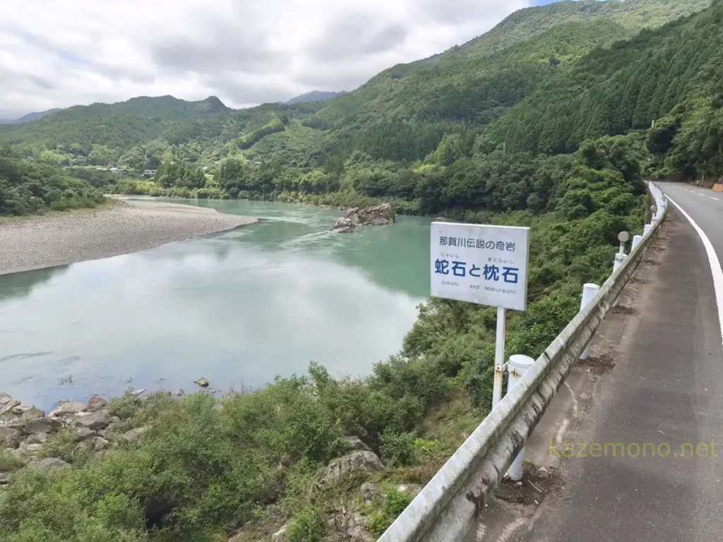 那賀川沿いに立つ「蛇石と枕石」の看板と川の景色