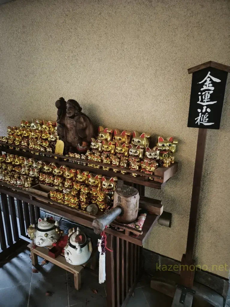 お松大権現の金色の招き猫と木製の金運小槌